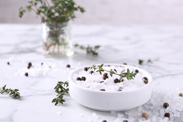 Obraz na płótnie Canvas Salt with thyme and peppercorns in bowl on white marble table. Space for text