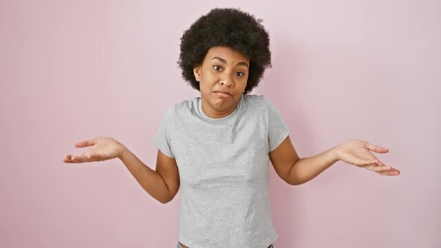 Furious african american woman in pink background, screaming loud with hand on mouth. outrage pouring, standing isolated, wearing a t-shirt. communication with rage, crazy yet beautiful.