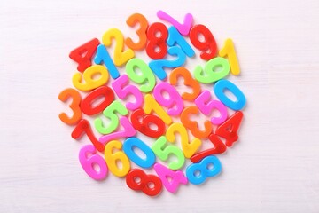 Colorful numbers on white wooden school desk, top view