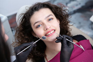 Dentist examining teeth of a young woman patient in a dental clinic. Dentistry concept. Dentist and patient in the dental office.