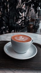 Close up of a light brown fresh mocha with beautiful latte art outdoors on a cafe in Paris