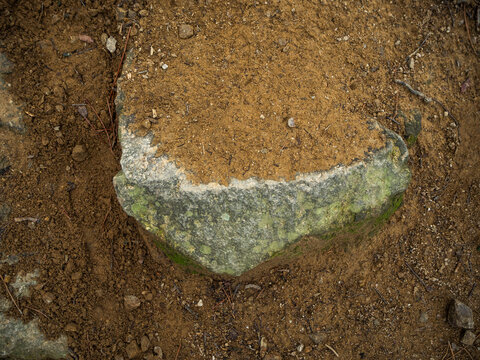 imagen detalle piedra gris enterrada por la arena 