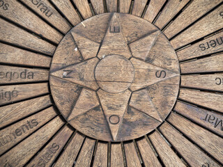 imagen de una rosa de los vientos tallada sobre una tabla de madera 