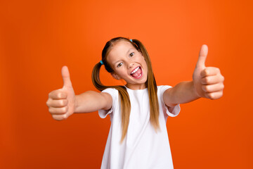 Photo of positive funky girl hands fingers demonstrate thumb up approval isolated on orange color background