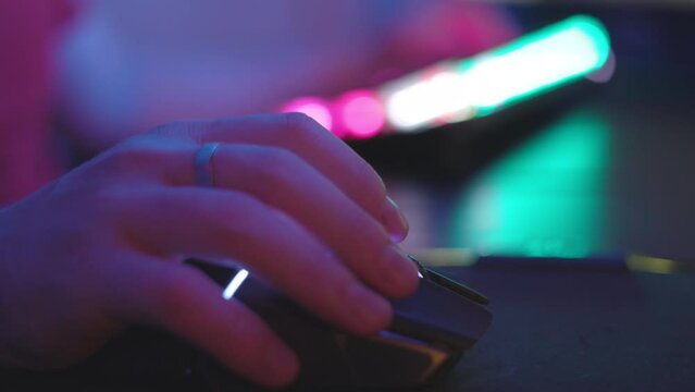 Close up. Gamer fingers clicking on PC mouse while playing video game and have streaming session on his computer.