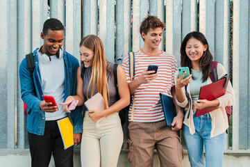 Group of young teenage high school students smiling and having fun using a social media app with...