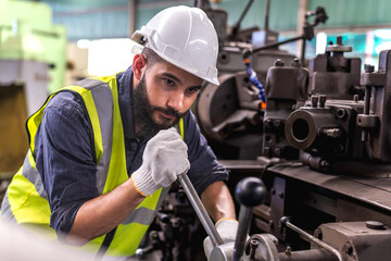 Portrait of engineer controlling heavy machinery working in industrial factory - obrazy, fototapety, plakaty