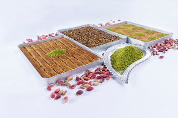 Top view of shredded phyllo dough dessert species with pistachio on trays isolated on white...