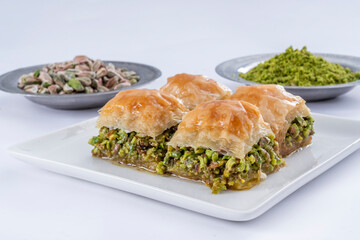 Close up view of traditional Turkish cuisine dessert, pistachio baklava on a white plate. Ground...