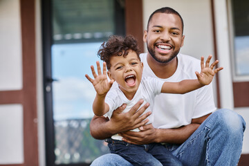 happy african american man in braces hugging excited son while sitting on porch of modern house