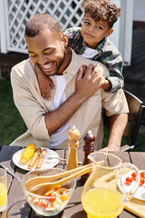 smiling african american child hugging excited father in braces on backyard of house, family time