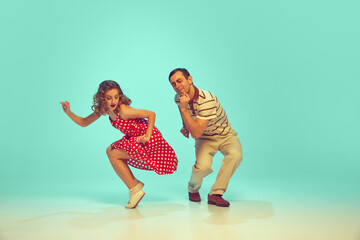 man and woman, talented dancers in retro style clothes dancing swing, boogie-woogie against...
