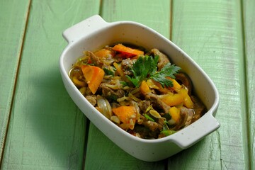 Delicious  beef teriyaki, carrot and yellow peppers in rectangular bowl with on rustic background. Masakan