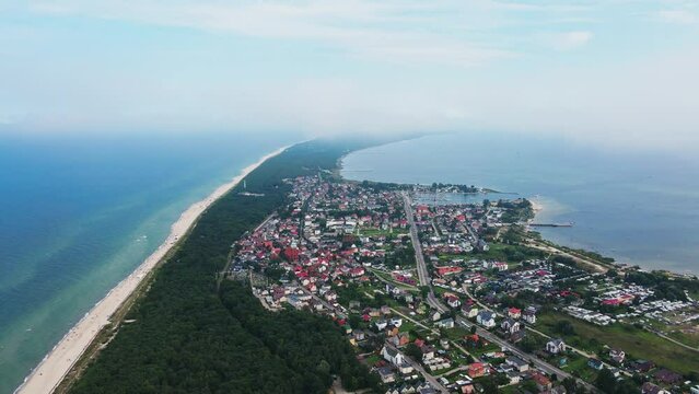 Birds eye view of sea landscape with sandy beach and Jastarnia city on Hel peninsula. Baltic Sea coast in Poland. Resort town in the summer season