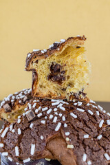 Fetta di colomba pasquale artigianale ripiena di crema al cioccolato poggiata sopra la colomba pasquale intera 