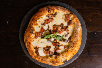 Pizza tradizionale napoletana con mozzarella, melanzane a funghetto fritte, pomodori e basilico...