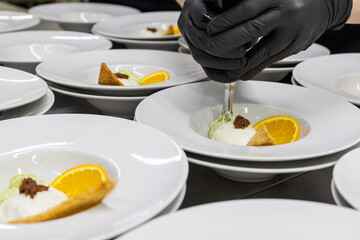 Chef di un ristorante da banchetto mentre ultima gli antipasti con una spuma utilizzando un sifone...