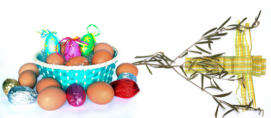 Easter studio shot with eggs, cloth cross, and olive branch isolated on white.