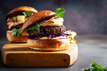 Beef burgers with pickles and red onion on cutting board - 740877405