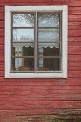Fototapeta na wymiar White framed window on old red painted wood wall.