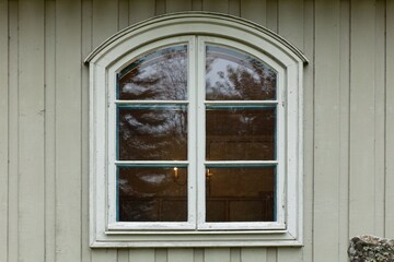 Old white framed window on a wood building.