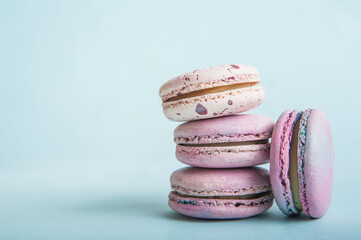 Pink macaroons on blue background close-up and empty space