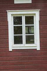 White framed window on old red painted wood wall.