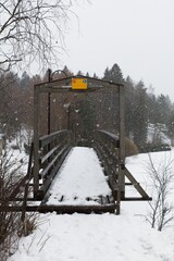 Old wooden bridge over Mustijoki river in cloudy winter weather, Laukkoski, Pornainen, Finland.