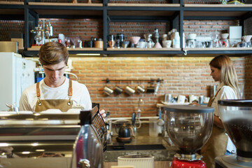 Professional caucasian coffee barista making a cup of coffee by using a modern espresso machine. 