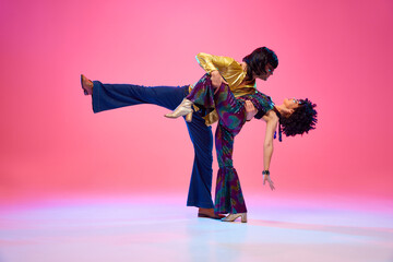 Echoes of 70s. Dance duo, female and male dancers posing in vivid retro fashion outfits against...