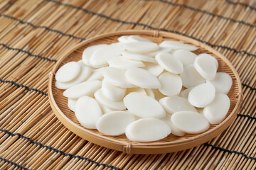 slice Tteok or slice Korean rice cake in bowl on bamboo table food background.