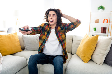 Obraz premium Photo of impressed funky guy wear plaid shirt turning off scary horror movie indoors room home house