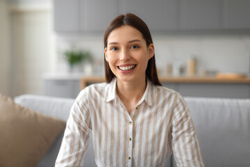 Portrait of smiling young woman in casual shirt at home