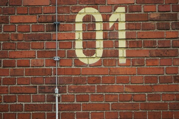Die Ziffern Null und Eins auf einer rotbraunen Backsteinmauer im Sommer bei Sonnenschein in der Klassikstadt im Stadtteil Fechenheim in Frankfurt am Main in Hessen