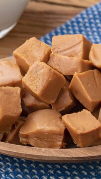 Vertical video. Doce de leite or dulce de leche, traditional south american milk candy with ingredients over wooden table