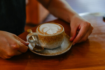Female hands holding a cappuccino. Coffee with nut milk. - obrazy, fototapety, plakaty