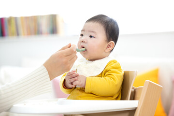 이유식을 먹는아기와 먹여주는 엄마의 손