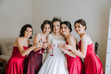 Photo with bridesmaids drinking champagne from glasses in the morning in a beautiful hotel. Photo...