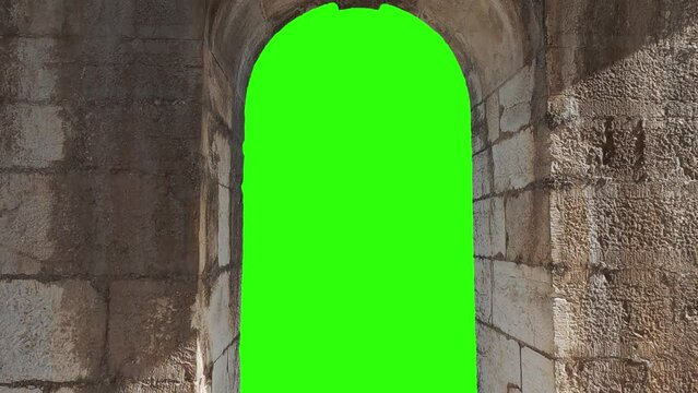 A window stone arch in medevial fortress wall with green chroma and alpha chanel to be used as foreground layer. You can replace green screen with the footage or picture you want