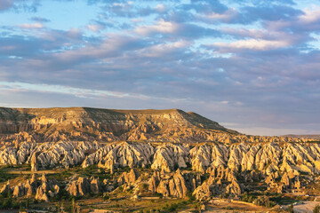 Landscape of Goreme valley in Cappadocia with blue sky and beautiful clouds at background. Golden...