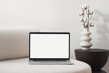 Laptop computer with empty blank mockup screen over white modern living room design. Advertisement,...