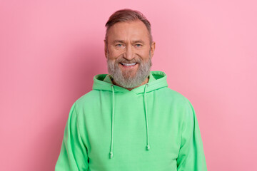 Photo of good mood cheerful guy dressed green hoodie smiling white teeth isolated pink color background