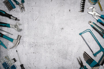 Assorted Hand Tools Laid Out on concrete background, top view with space for text