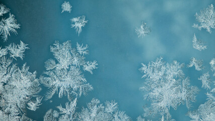 Fototapeta na wymiar ice pattern on glass and blue background