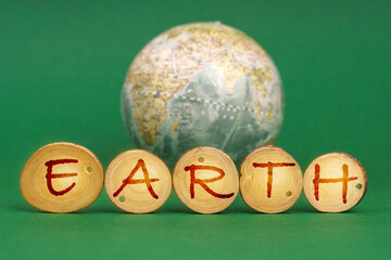 On a green background there is an Earth globe and wooden roundels with the inscription - Earth