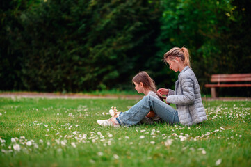 Naklejka na ściany i meble Tender moment between mother and daughter in a serene park setting