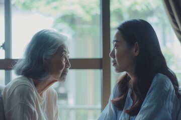 A caregiver from Asia and an older woman are in the room