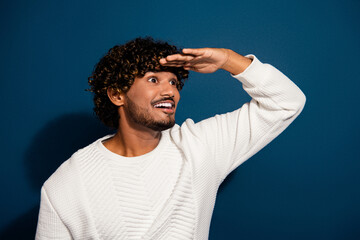 Photo of young man curly hair indian model touch forehead searching looking far away distance...