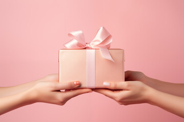 Woman hands gives a gift to another girl on a pink background