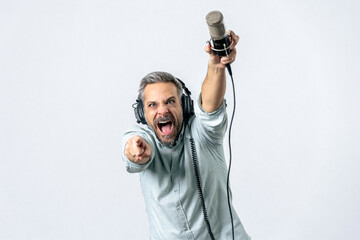 Handsome man with headphones and mic against white background.